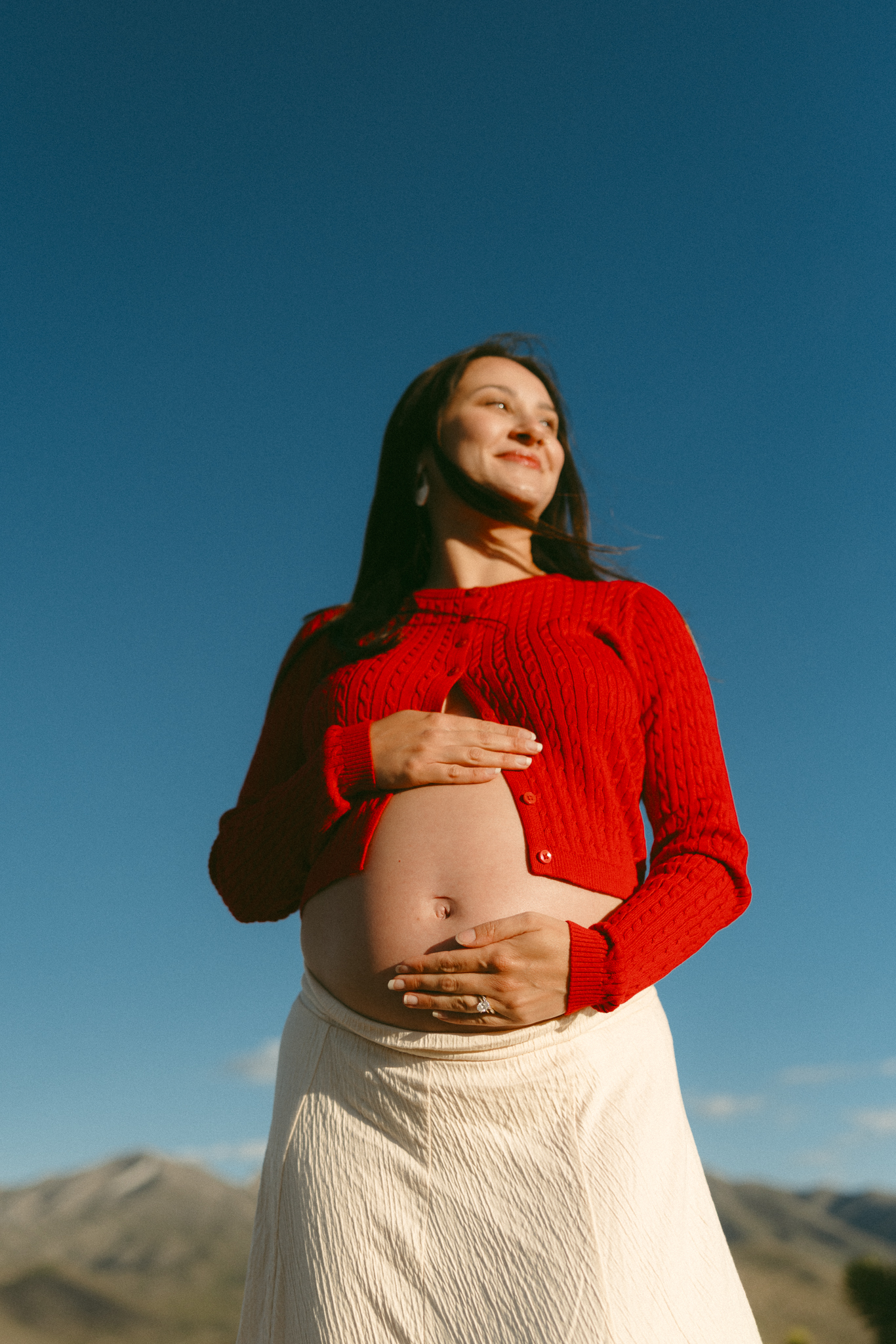 expecting mom in red sweater maternity photos blue sky